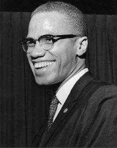 a black and white image of Malcolm X